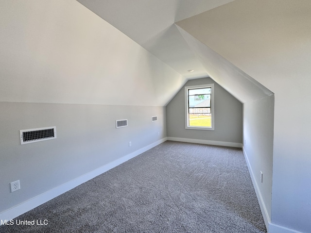 additional living space featuring lofted ceiling, carpet flooring, visible vents, and baseboards