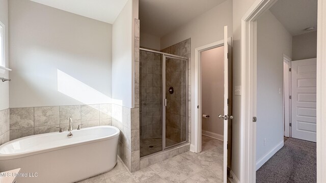 bathroom featuring plus walk in shower and tile patterned flooring