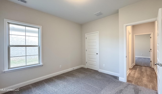 unfurnished bedroom with multiple windows, a closet, and carpet floors