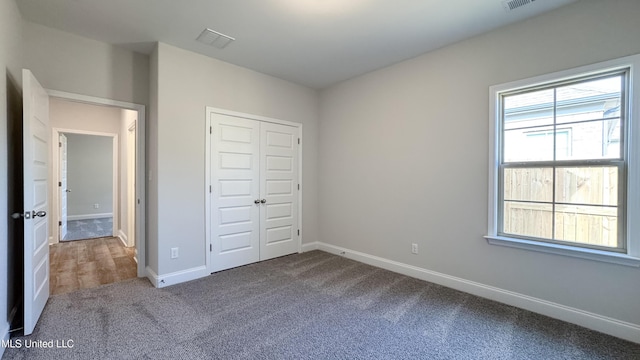 unfurnished bedroom featuring carpet floors and a closet