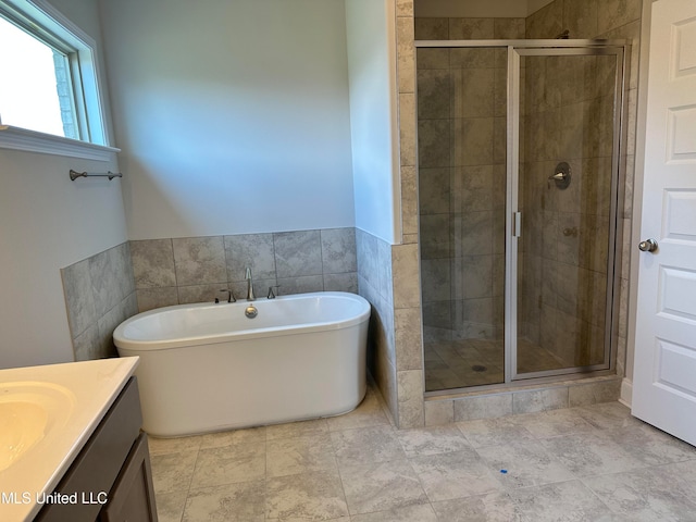 bathroom featuring vanity, independent shower and bath, and tile walls