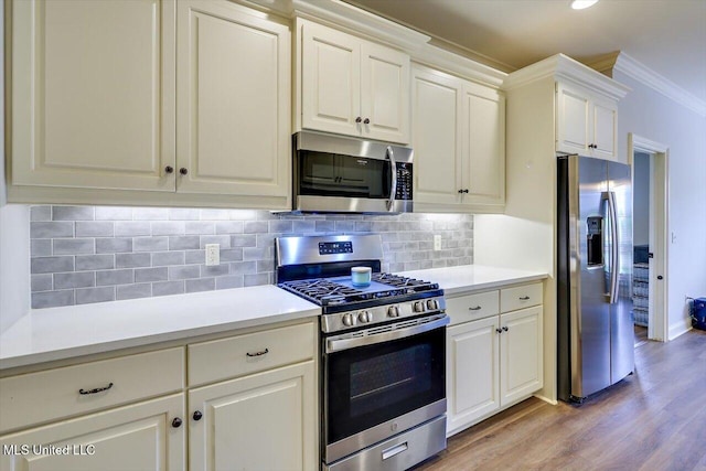 106 Sumter Dr, Canton, MS 39046 - kitchen with appliances with stainless steel finishes, crown molding, light wood finished floors, light countertops, and tasteful backsplash
