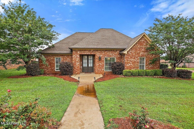 106 Sumter Dr, Canton, MS 39046 - view of front facade with brick siding, a front lawn, and french doors