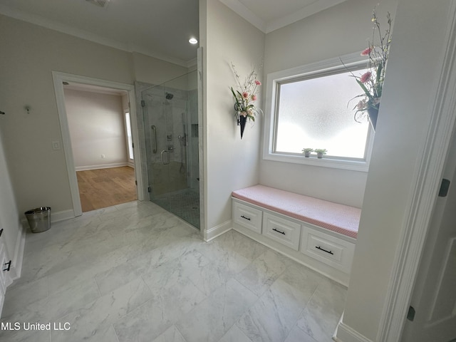 bathroom featuring ornamental molding and a shower with shower door