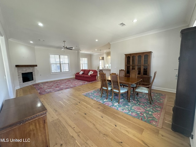 dining room with ceiling fan, ornamental molding, and light hardwood / wood-style flooring