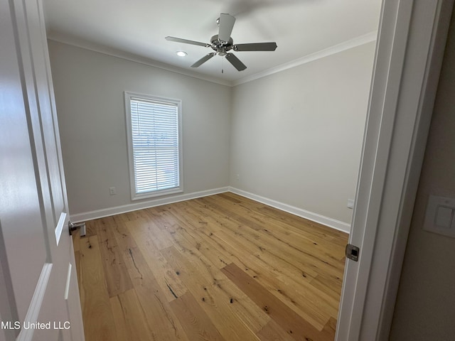 spare room featuring crown molding, light wood-type flooring, and ceiling fan