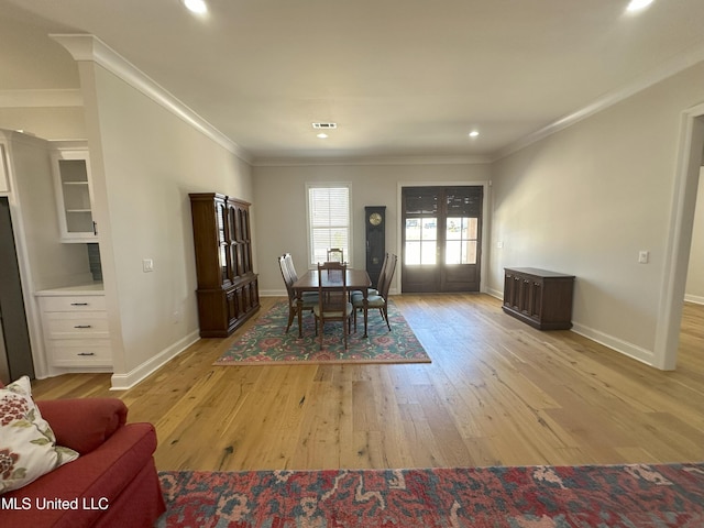 dining room featuring light hardwood / wood-style floors and ornamental molding