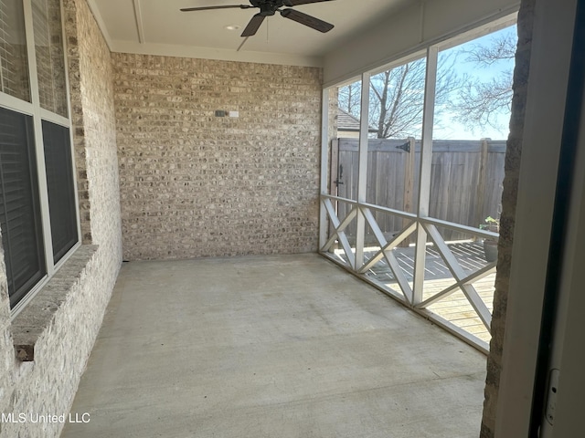 unfurnished sunroom featuring ceiling fan