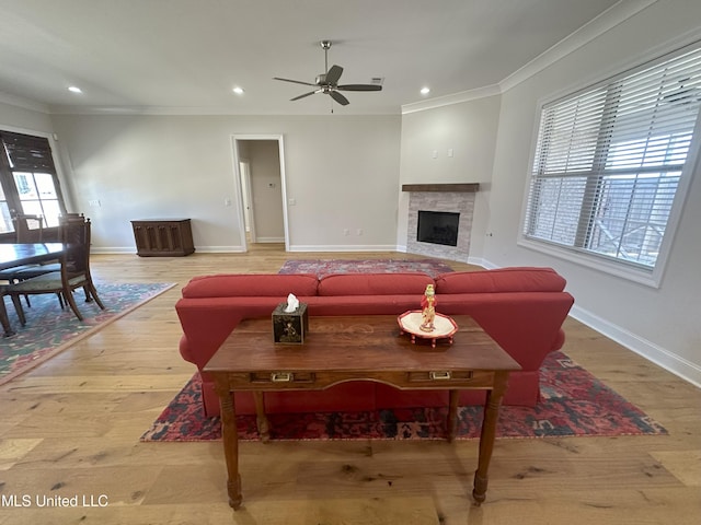 living room with ornamental molding, hardwood / wood-style flooring, and ceiling fan