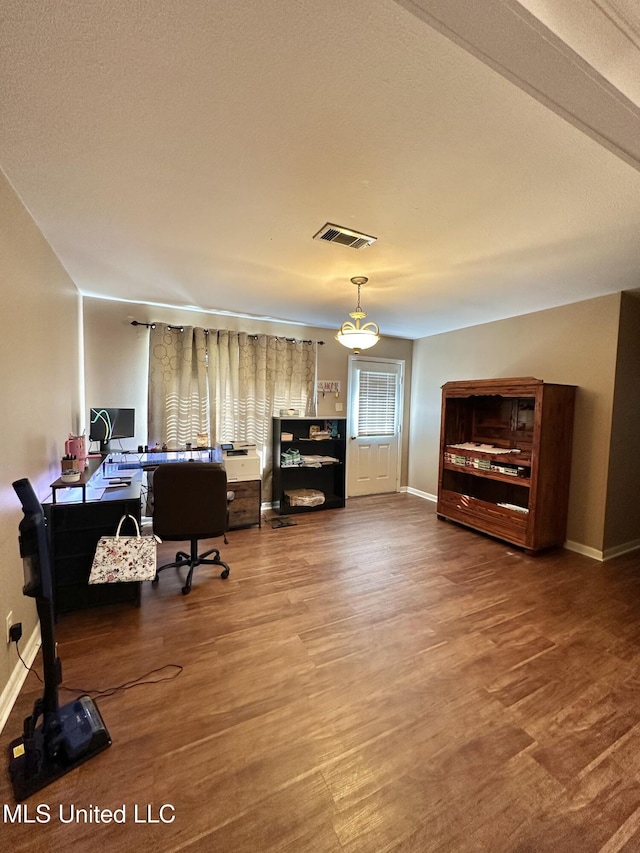 home office with visible vents, baseboards, and wood finished floors