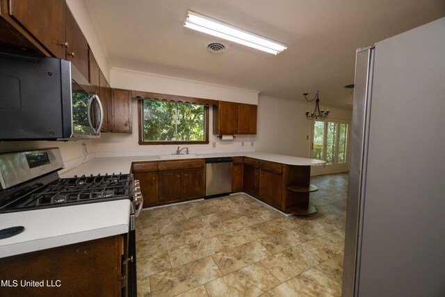 kitchen with sink, kitchen peninsula, stainless steel appliances, and plenty of natural light