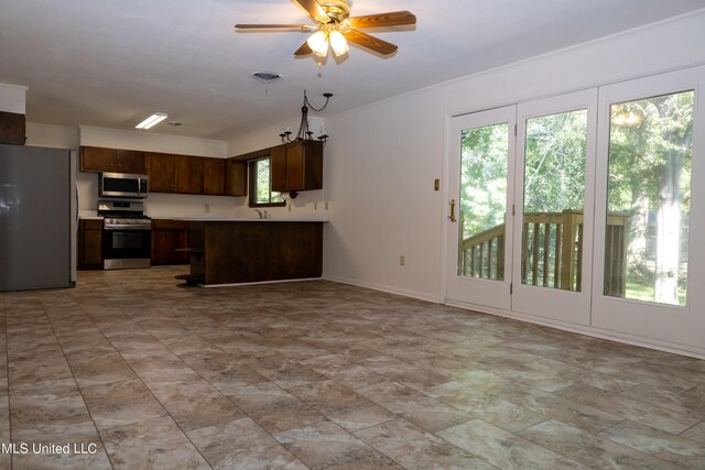 kitchen featuring appliances with stainless steel finishes, kitchen peninsula, and ceiling fan with notable chandelier