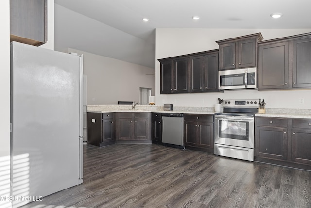 kitchen featuring a sink, appliances with stainless steel finishes, light countertops, dark brown cabinets, and vaulted ceiling