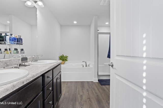 bathroom featuring a sink, a garden tub, a stall shower, and wood finished floors