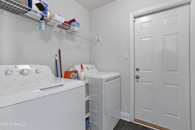 laundry area featuring washer and clothes dryer, laundry area, dark wood finished floors, and baseboards