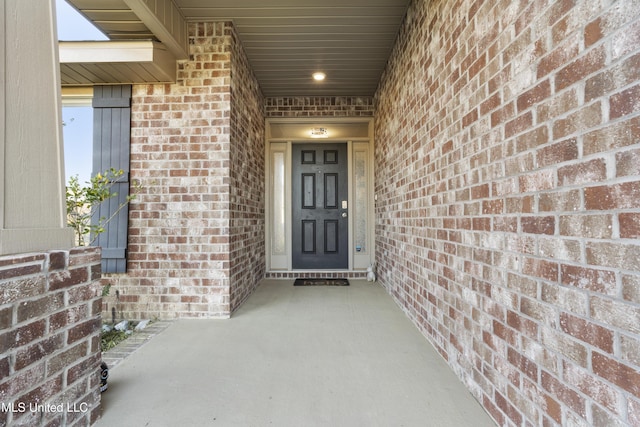 view of exterior entry with brick siding