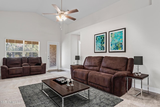 living room with baseboards, light colored carpet, ceiling fan, and high vaulted ceiling