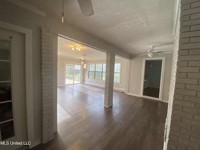 spare room featuring ornate columns, ceiling fan, hardwood / wood-style floors, and a textured ceiling