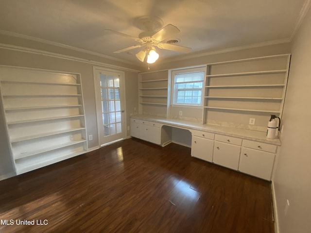 unfurnished office featuring ceiling fan, crown molding, built in desk, built in features, and dark hardwood / wood-style floors