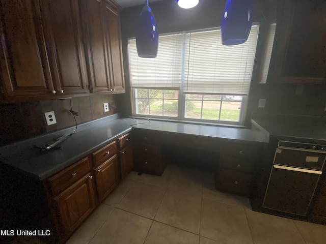 kitchen with dark brown cabinetry, decorative backsplash, and light tile patterned floors