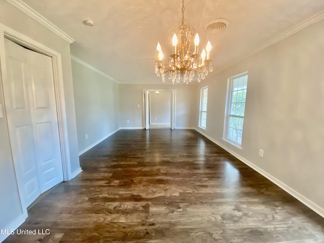 unfurnished dining area featuring dark wood-type flooring, ornamental molding, and a notable chandelier