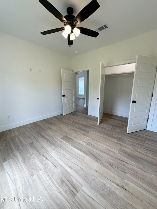 unfurnished bedroom with ceiling fan, a closet, and light wood-type flooring