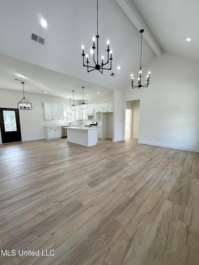 unfurnished living room with an inviting chandelier, high vaulted ceiling, beam ceiling, and light hardwood / wood-style floors