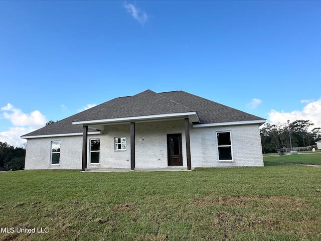 rear view of property featuring a lawn and a patio