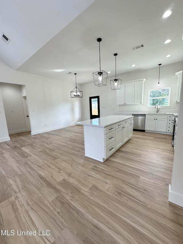 kitchen featuring white cabinetry, decorative light fixtures, stainless steel appliances, and a kitchen island