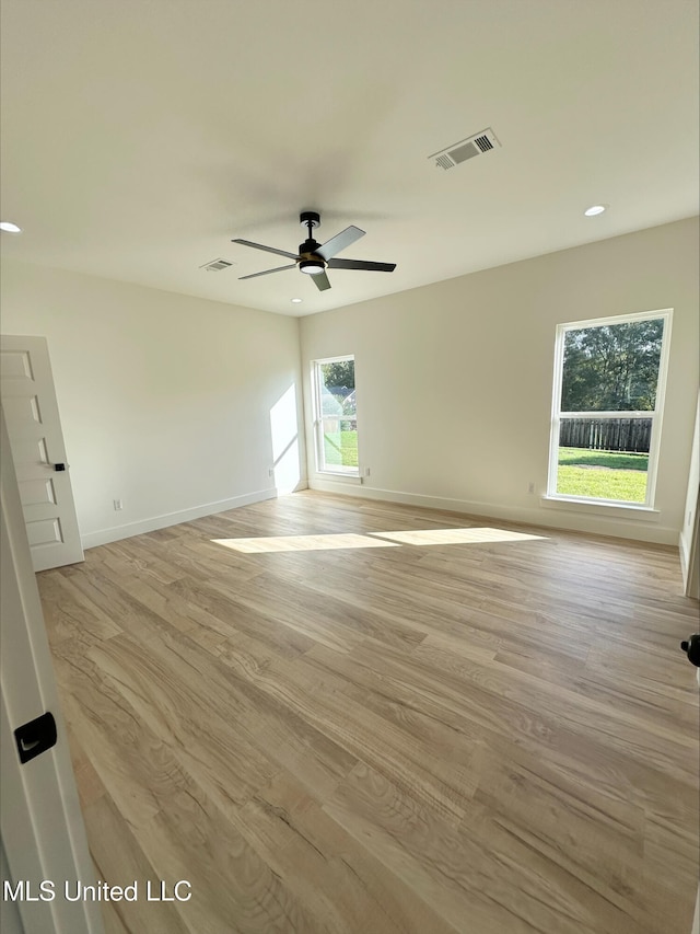 unfurnished room with light wood-type flooring, a wealth of natural light, and ceiling fan