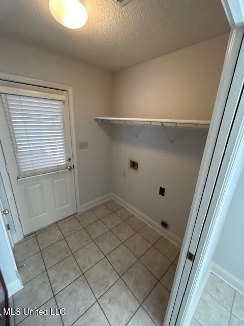 laundry area featuring a textured ceiling, washer hookup, and light tile patterned floors