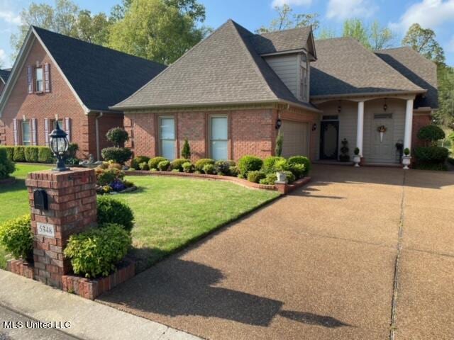 view of front of home featuring a front yard and a garage