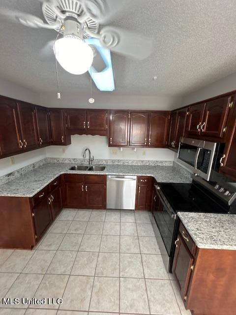 kitchen with sink, appliances with stainless steel finishes, a textured ceiling, and light tile patterned flooring