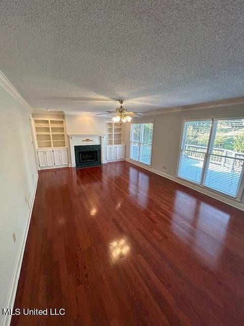 unfurnished living room with ceiling fan, a textured ceiling, dark hardwood / wood-style flooring, and ornamental molding