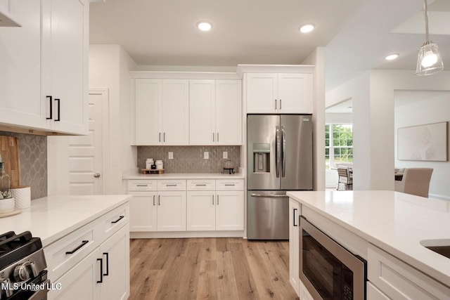 kitchen featuring backsplash, white cabinets, built in microwave, stainless steel fridge with ice dispenser, and decorative light fixtures