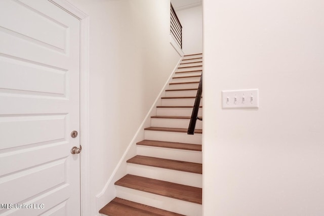 stairs featuring hardwood / wood-style flooring