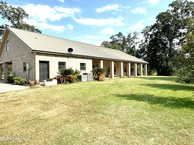 rear view of house with a lawn and central AC