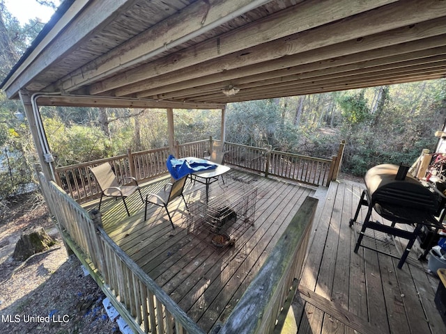 wooden deck with a grill and a wooded view