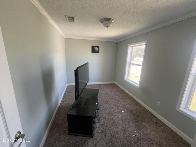 unfurnished living room featuring visible vents, baseboards, ornamental molding, carpet floors, and a textured ceiling