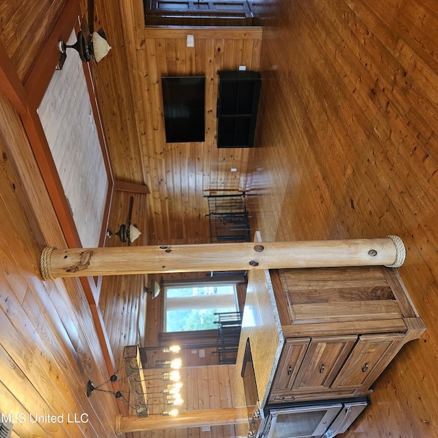 interior space featuring wood walls, hardwood / wood-style floors, and a high ceiling