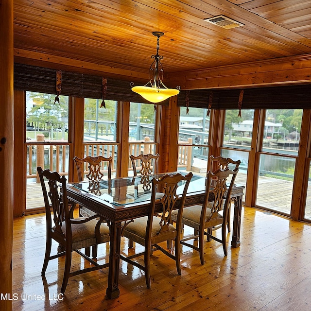 dining space featuring light wood-type flooring and wooden ceiling