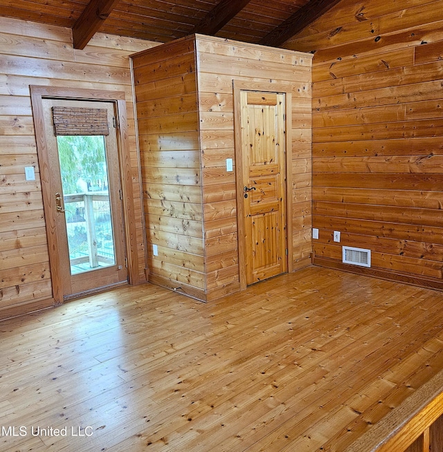 unfurnished room with beam ceiling, light hardwood / wood-style flooring, wooden walls, and wood ceiling