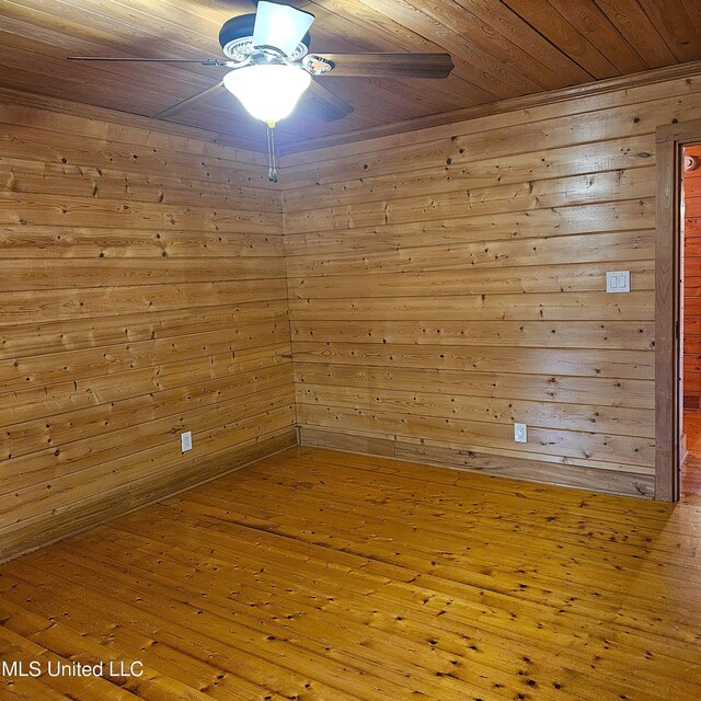 unfurnished room with wooden walls, wooden ceiling, and wood-type flooring