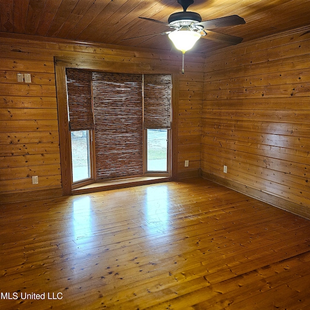 unfurnished room with hardwood / wood-style floors, wood ceiling, and wooden walls