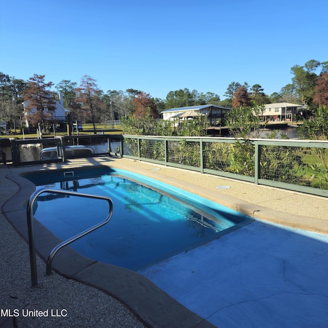 view of pool with a patio area and a water view