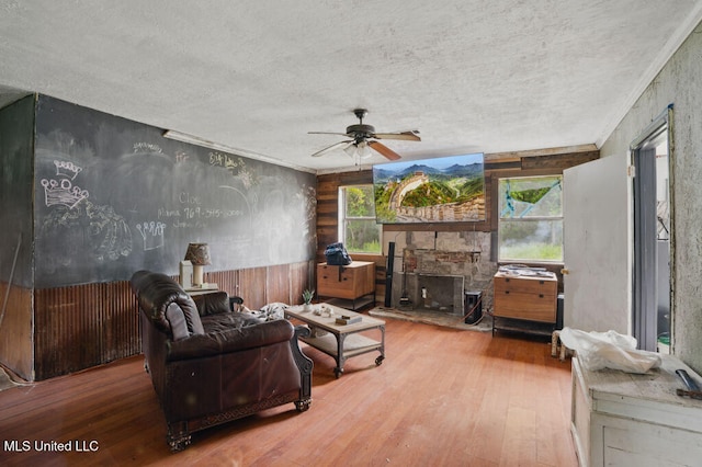 9 Gail St, Hattiesburg, MS 39402 - living room featuring a textured ceiling, wood finished floors, ceiling fan, and a stone fireplace
