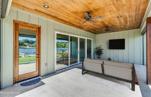 view of patio with a water view and ceiling fan