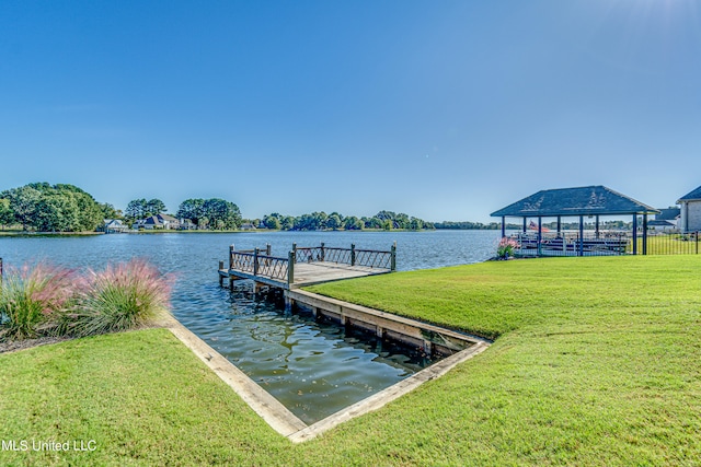 view of dock with a gazebo, a lawn, and a water view