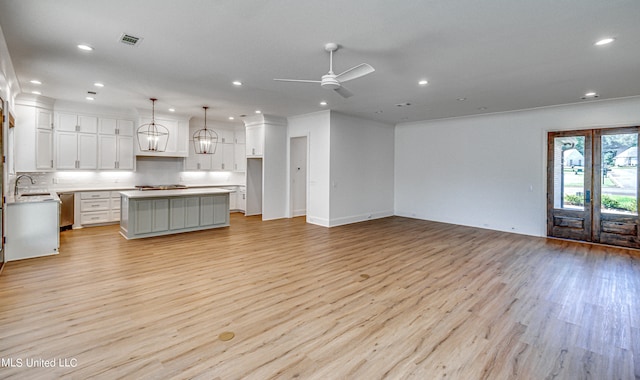 interior space with light hardwood / wood-style floors, sink, and ceiling fan with notable chandelier