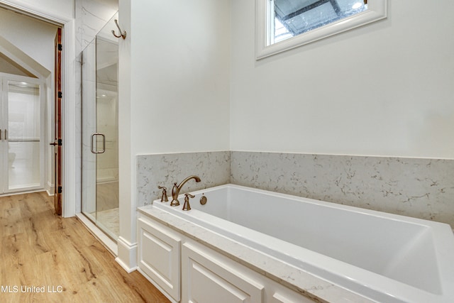 bathroom featuring separate shower and tub and hardwood / wood-style floors